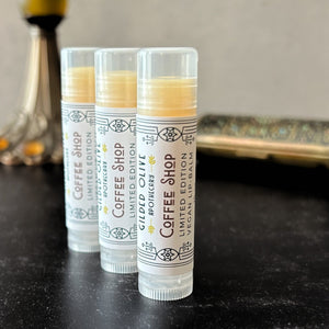 3 Coffee Shop Vegan Lip Balms on a dark surface