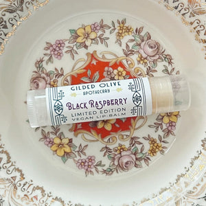 Black Raspberry Vegan Lip Balm resting on a vintage floral porcelain plate.