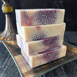 Black Raspberry Handmade soaps with cream and purple swirls, displayed on a vintage dish against a dark background.
