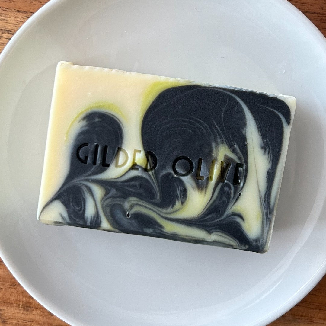 Charcoal Lime Handmade Soap on a white soap dish