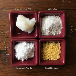 Natural deodorant ingredients in small square bowls on a wood surface