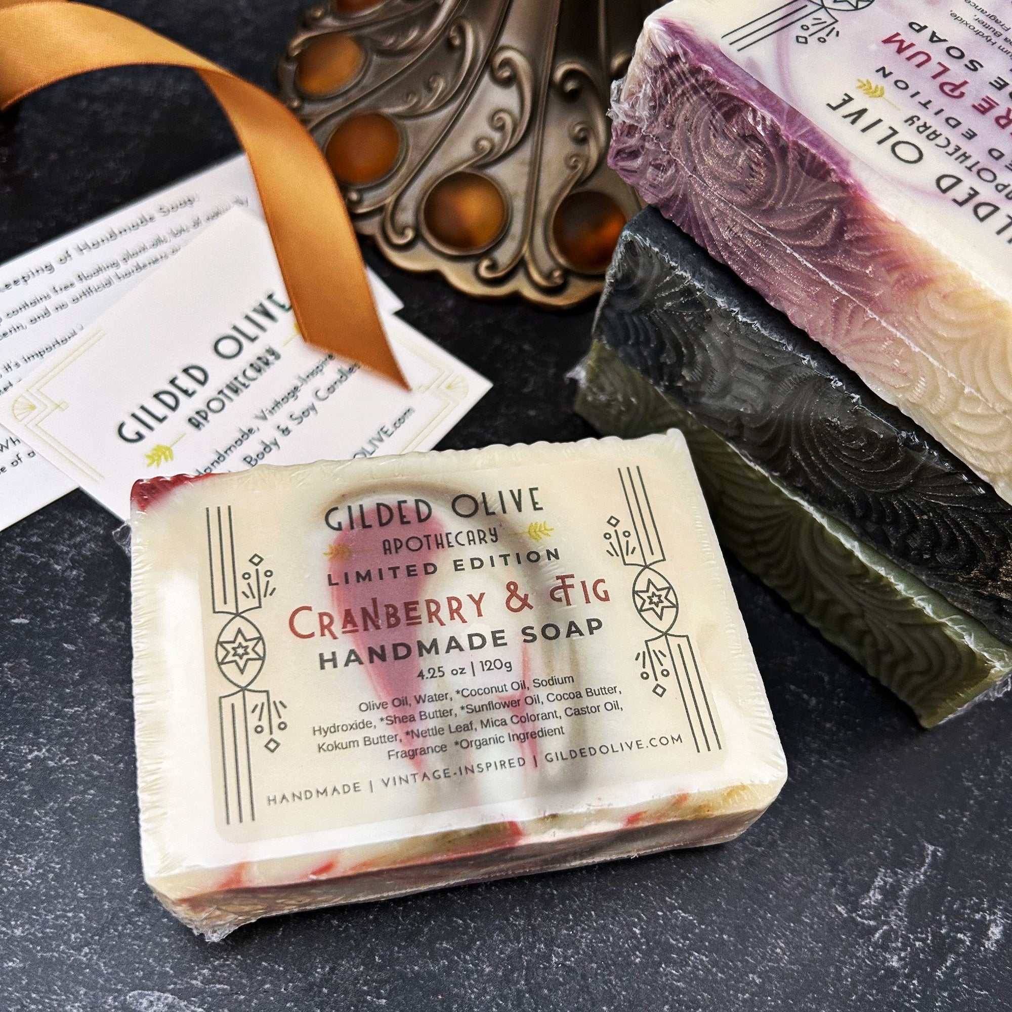 Holiday themed soap bars with packaging on a dark surface.