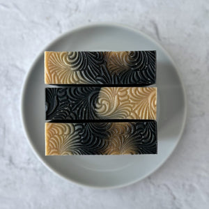 Three bars of Sacred Embers Soap on a white dish.