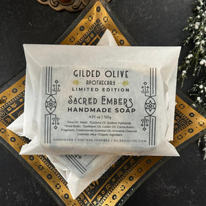 Sacred Embers Soap, packaged in a glassine bag in a gilded dish.