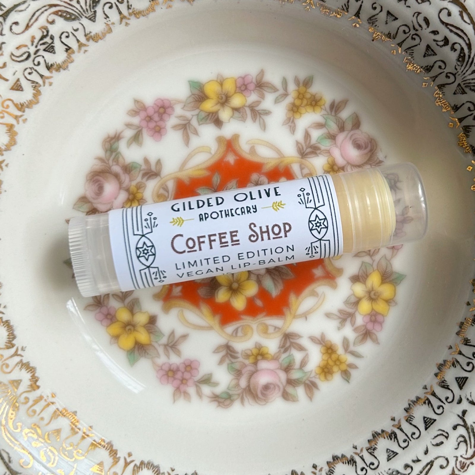 A single Coffee Shop Lip balm on a vintage dish