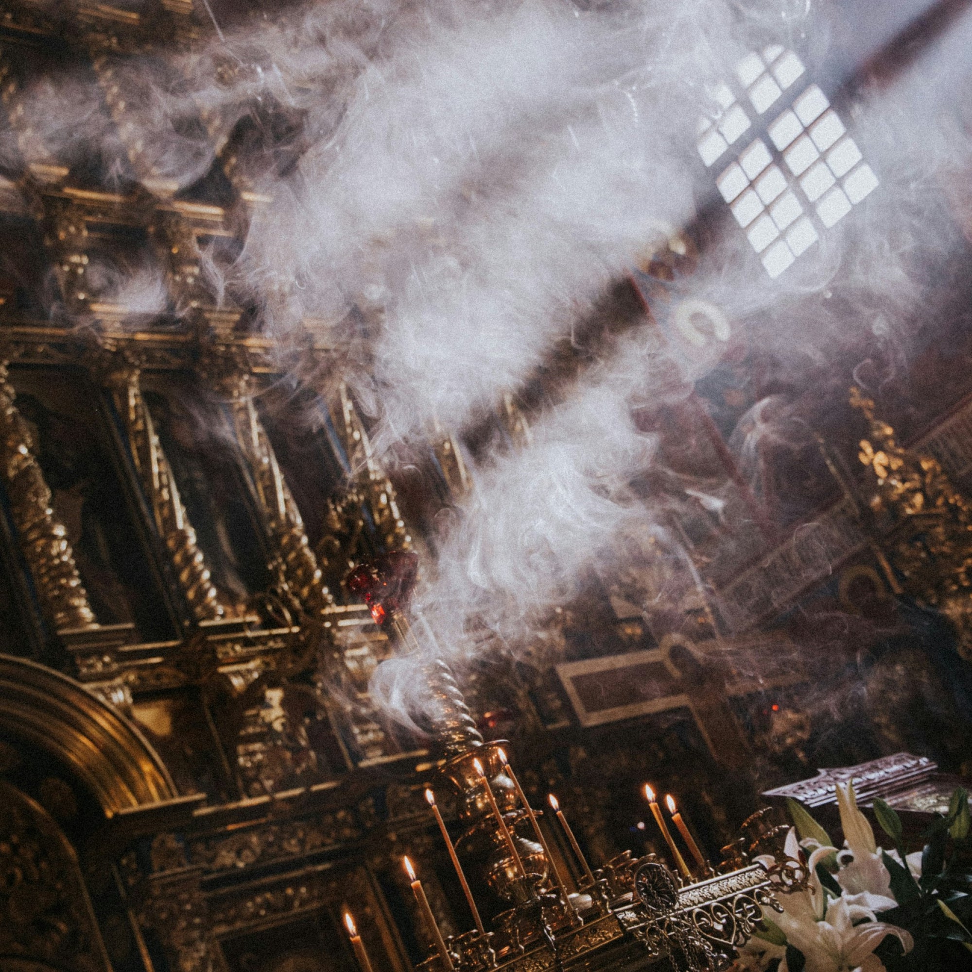 Decorative interior with intricate gold detailing and incense smoke.