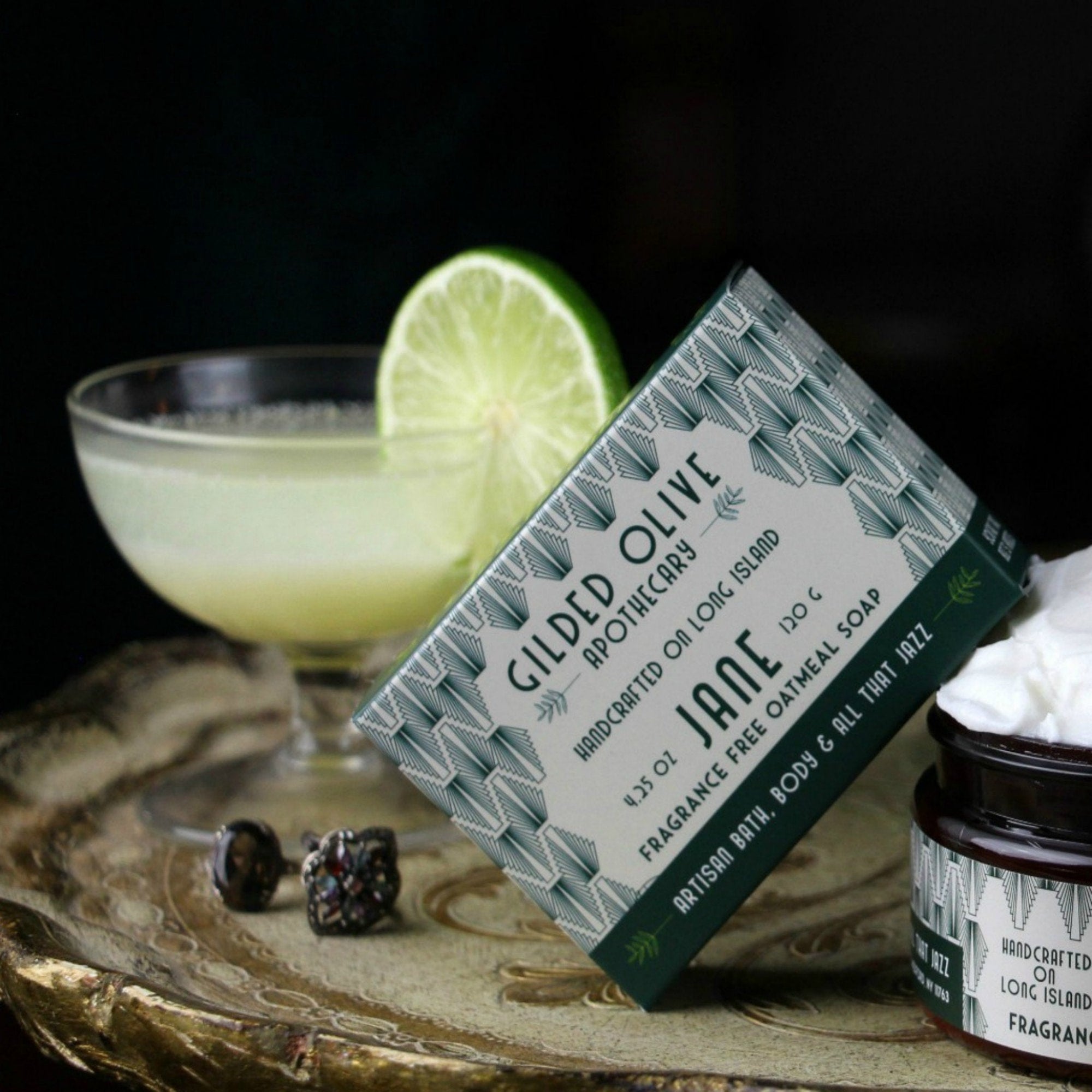 Jane, Fragrance Free Oatmeal Soap on a tray with a cocktail and whipped body cream 