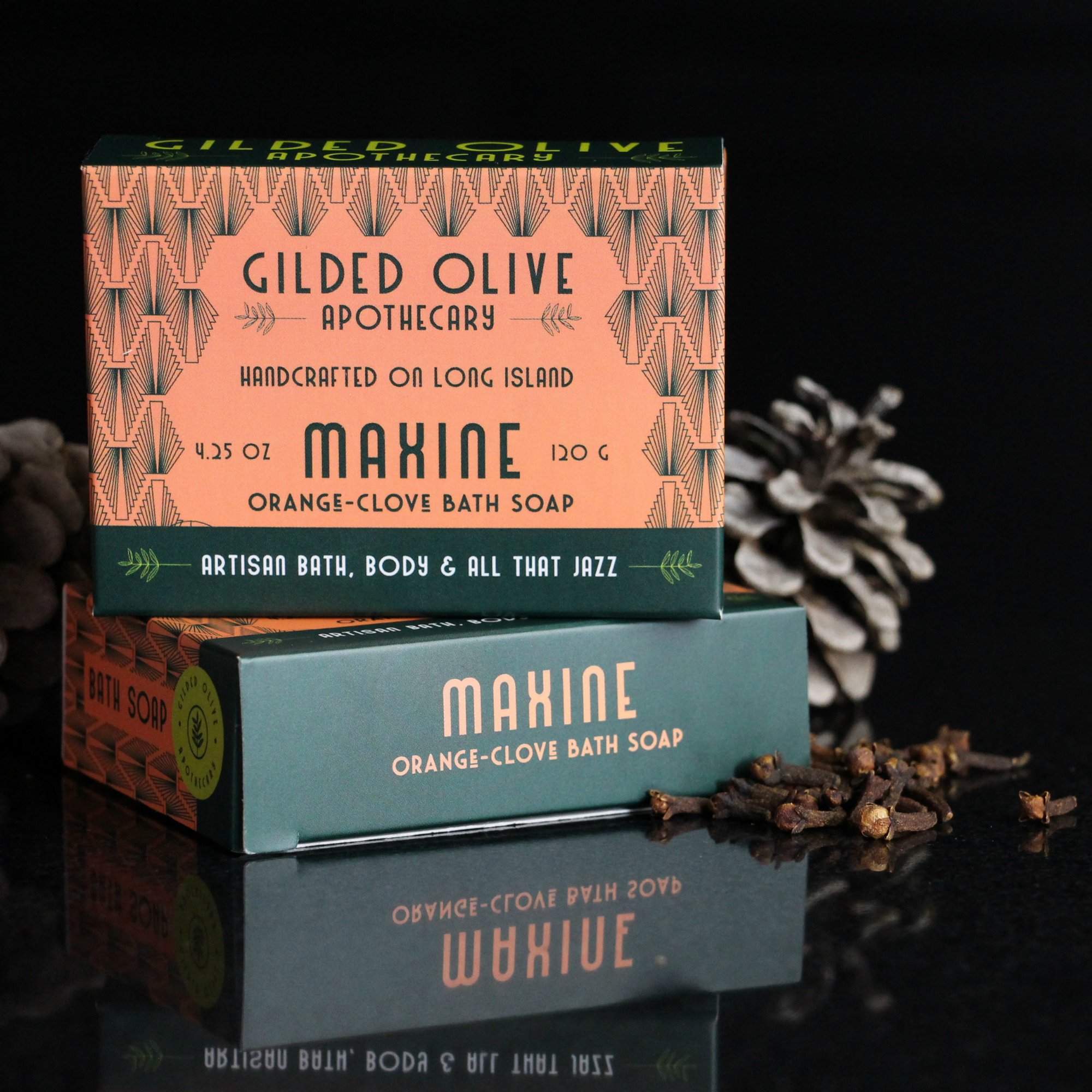 Maxine Orange Clove Soap on a tray with pinecones and cloves