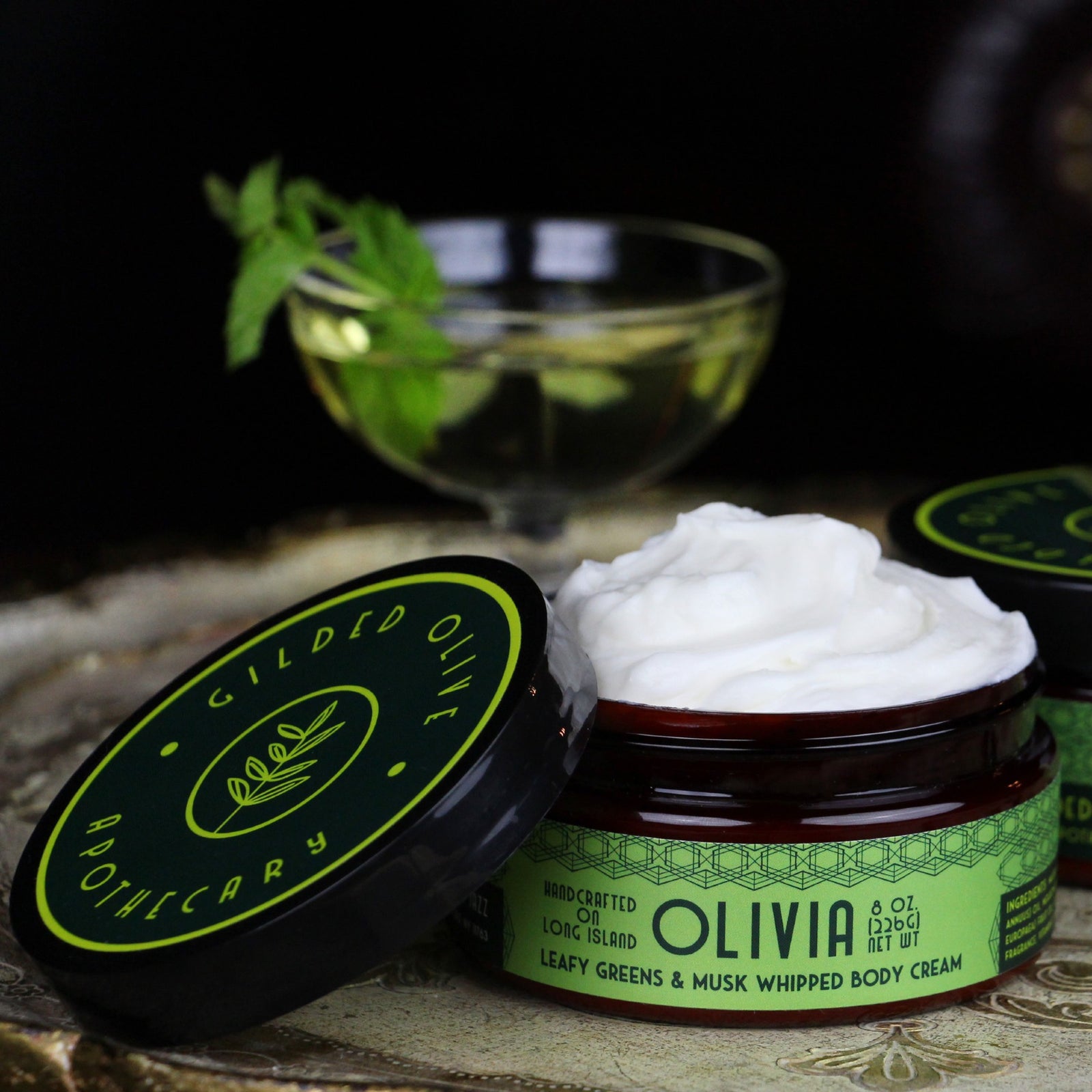 A jar of Olivia Whipped Body Cream on a vintage tray.