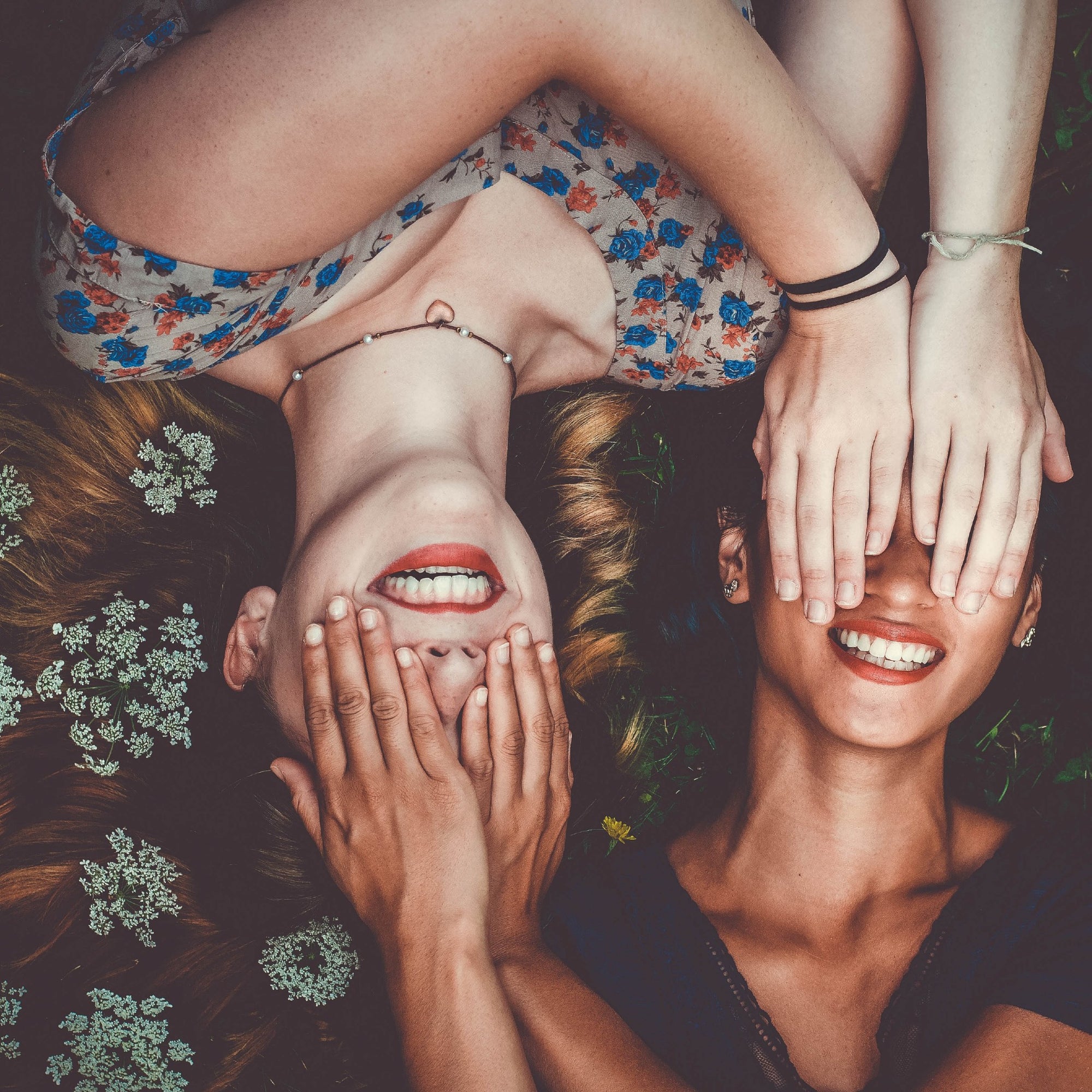 Two girls laying in grass on a summer evening