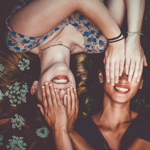 Two girls laying in grass on a summer evening